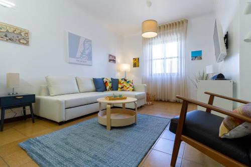 a living room with a white couch and a table at Apartment close to the Ria de Aveiro, São Jacinto in Aveiro