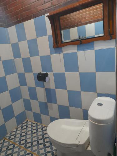 a bathroom with a white toilet and a window at Krobyongan staycation kalaras in Karanganyar