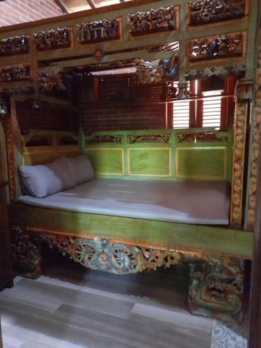 a bed in a room with a wooden frame at Krobyongan staycation kalaras in Karanganyar