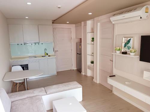 a kitchen with white cabinets and a white table at Seven Seas Condo Resort Jomtien Loft in Jomtien Beach