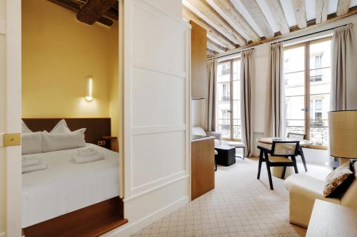 Pokój hotelowy z łóżkiem i biurkiem w obiekcie Pick A Flat's Apartments in Louvre - Rue Saint Honoré w Paryżu