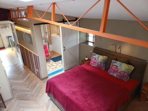 1 dormitorio con 1 cama grande con manta rosa en De Ketse Steenuil, en Kaatsheuvel