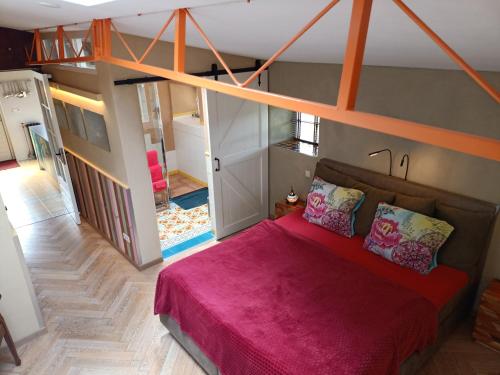 een slaapkamer met een groot bed en een roze deken bij De Ketse Steenuil in Kaatsheuvel