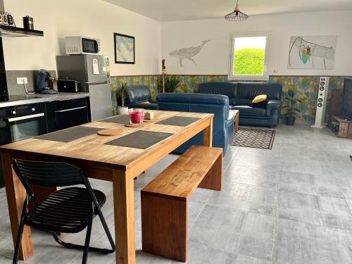 Il comprend une cuisine et un salon avec une table en bois. dans l'établissement L'Ostréa, maison avec jardin à 200m de la mer-wifi, à Saint-Côme-de-Fresné