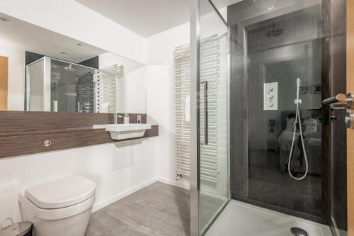 a bathroom with a toilet and a glass shower at Luxury Apartment with Balcony, Free Parking in St Andrews