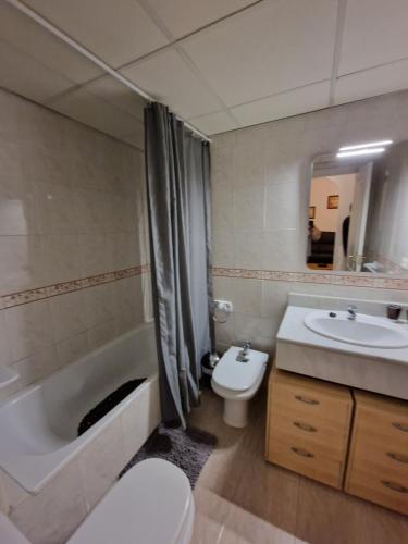a bathroom with a toilet and a tub and a sink at Apartamento playa - Puerto Banus in Marbella