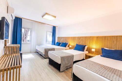 a hotel room with two beds and a couch at Costa Bodrum City in Bodrum City