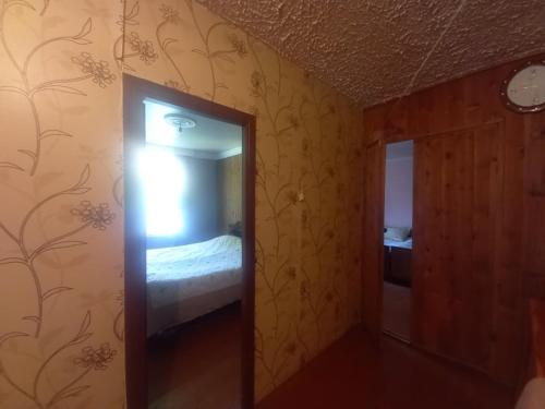 a mirror in a room with a bed and a bedroom at Maia's Guesthouse in Mestia