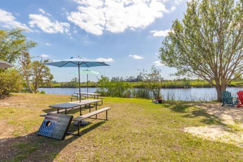 una mesa de picnic con una sombrilla junto a un lago en Waterfront Condo #10, en Punta Gorda