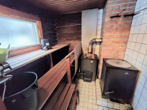 a small kitchen with a stove and a sink at Villa Haapala in Rovaniemi