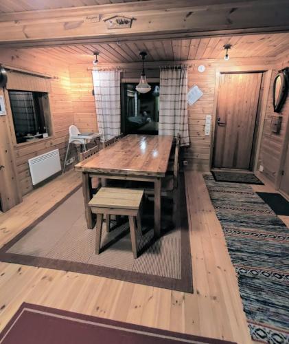 a dining room with a wooden table and benches at Villa Haapala in Rovaniemi
