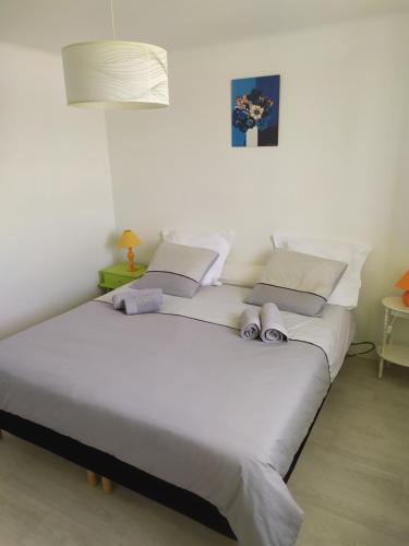 een slaapkamer met een groot wit bed met schoenen erop bij La Haute Maison - Merrien - GR34 in Moëlan-sur-Mer