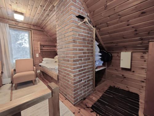 a room with a brick fireplace and a bed in it at Villa Haapala in Rovaniemi