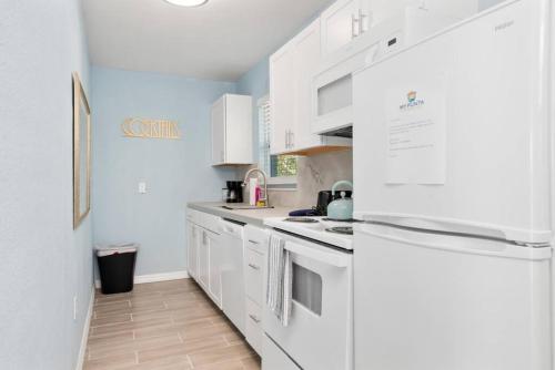 a white kitchen with white cabinets and a refrigerator at Waterfront Condo #9 in Punta Gorda