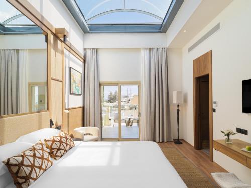 ein Schlafzimmer mit einem großen weißen Bett und einem Fenster in der Unterkunft Leonardo Boutique Hotel Larnaca in Larnaka