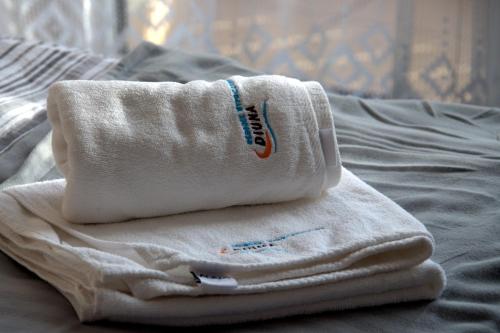 a pile of towels sitting on top of a bed at Ośrodek Wypoczynkowy Diuna Beskidy in Korbielów