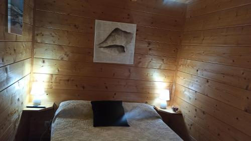 1 Schlafzimmer mit Holzwänden und 1 Bett mit 2 Lampen in der Unterkunft Veiga de Cohido in Vilagarcia de Arousa