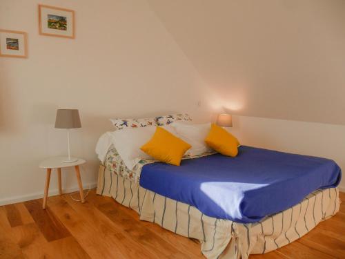 sypialnia z łóżkiem z niebieską pościelą i żółtymi poduszkami w obiekcie Maison Neuve Confortable Proche Plages à Locmaria – Jardin, Terrasse, Wifi, Classée 3* - FR-1-418-209 w mieście Locmaria
