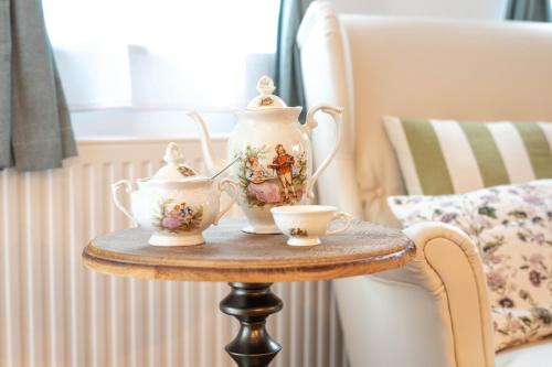 einen Tisch mit einer Teekanne und zwei Tassen darauf in der Unterkunft Alpine apartments Marcella in Žirovnica
