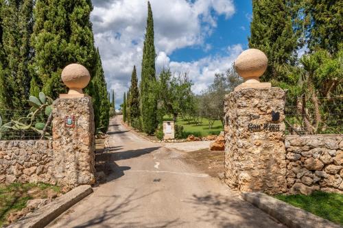 two statues standing on a stone gate in a road at Casa Pina in Costitx