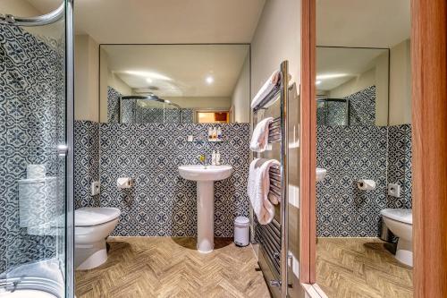 a bathroom with a sink and a toilet and a shower at The Globe Inn in Wells next the Sea