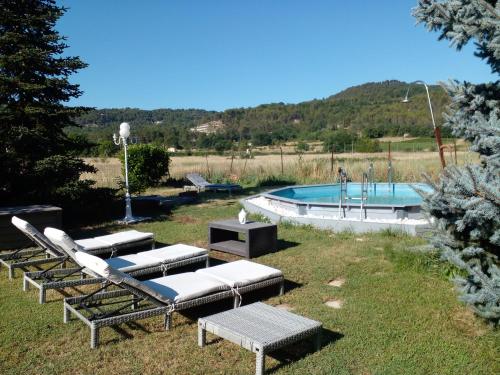 un grupo de tumbonas junto a la piscina en Location zen en Provence, en Mormoiron