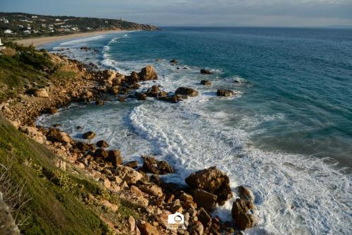 an aerial view of a rocky beach with the ocean at Tottam Art & Healthy Garden in Málaga