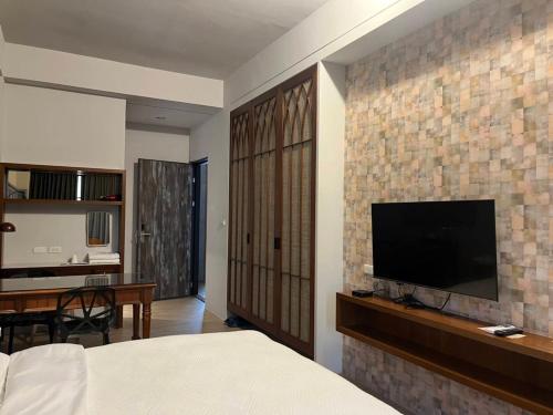 a bedroom with a flat screen tv on a brick wall at Fu's house 52 in Tainan