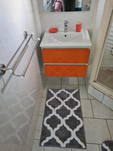 ein Bad mit einem Waschbecken und einem Spiegel in der Unterkunft Résidence JB in Sinnamary