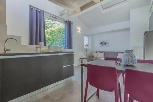 a kitchen and dining room with a table and purple chairs at La terrazza di Marta in Varenna