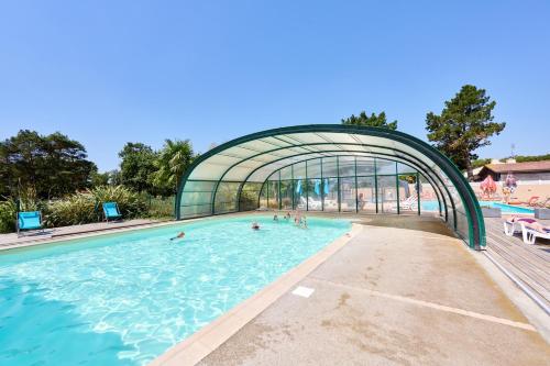 un gruppo di persone che nuotano in piscina di Glamping Vendée a Saint-Julien-des-Landes
