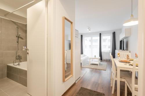 baño con ducha y cocina con comedor. en White Cottage Studio en Budapest