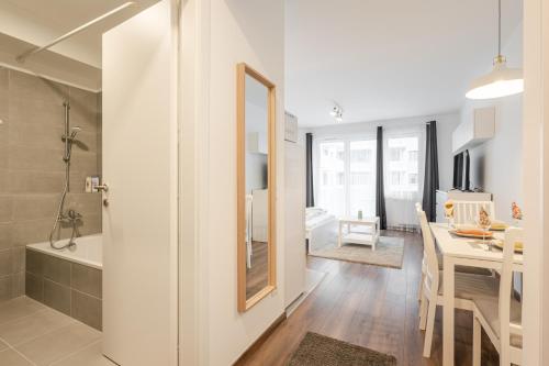 a bathroom with a shower and a kitchen with a dining room at White Cottage Studio in Budapest