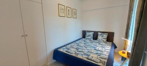 a bedroom with a bed with a blue comforter at APARTAMENT NIEBIESKA FALA in Rowy