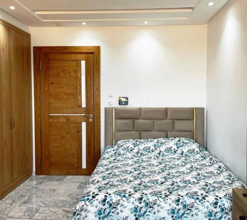 a bedroom with a bed and a wooden door at Studio avec vue directe mer in Monastir