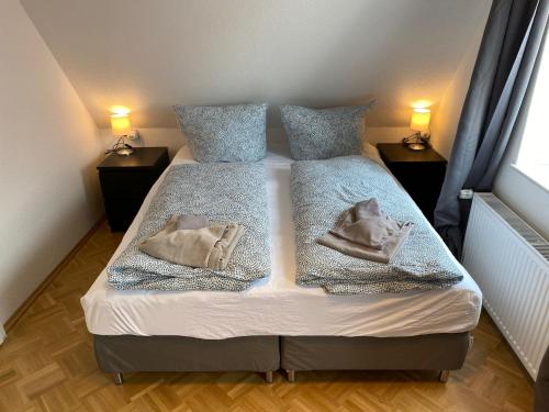 a bed in a room with two pillows on it at Ferienhaus am Seedeich in Emden