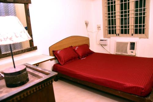 a bedroom with a red bed with a microwave at Steve homestay, near white town, near rock beach in Pondicherry