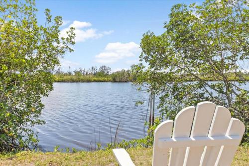 una sedia bianca seduta di fronte a un lago di Beautiful waterfront condo 1 a Punta Gorda