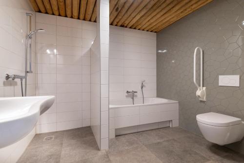 uma casa de banho com uma banheira, um WC e um lavatório. em Koe in de Kost em Heeten