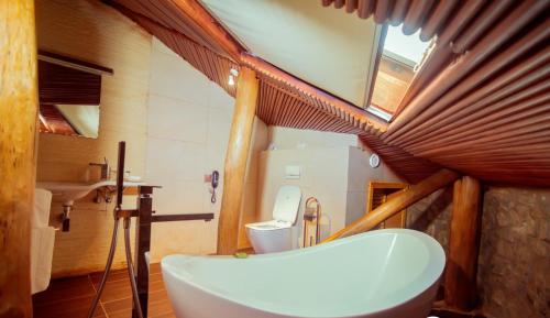 La salle de bains est pourvue d'une baignoire, de toilettes et d'une fenêtre. dans l'établissement Trois Ore Residences & Green Earth Bistro, à Ibadan