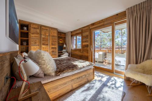 ein Schlafzimmer mit einem Bett und einem großen Fenster in der Unterkunft Le Grimpeur, Mer de Glace Spa Access, 50m from ski lift in Nendaz