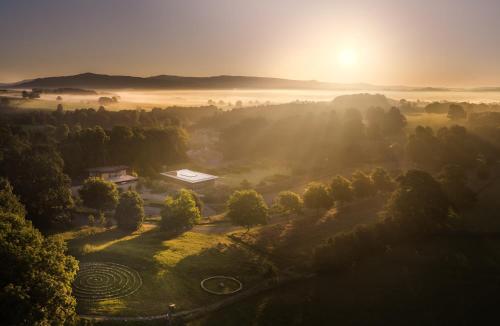 a misty sunrise over a field with the sun in the background at 2 Sulphur Wells at Broughton Sanctuary in Broughton
