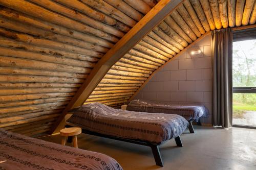 Duas camas num quarto com tecto em madeira em Koe in de Kost em Heeten