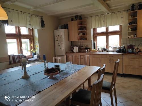 a kitchen with a wooden table with chairs in it at Komfortowy dom wakacyjny dla kilku rodzin 
