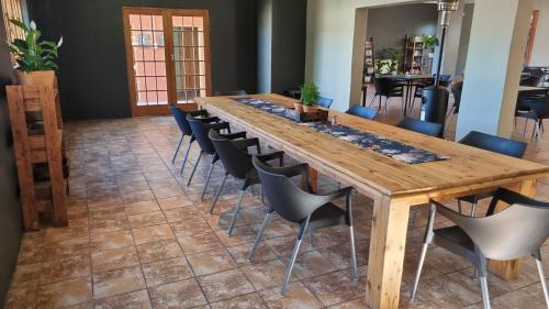 a long wooden table and chairs in a room at Pro Plants Accommodation in Kimberley