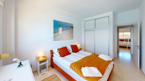 a bedroom with a large bed with orange pillows at Olimpo II The Cruise - Front Line Beach in Fuengirola