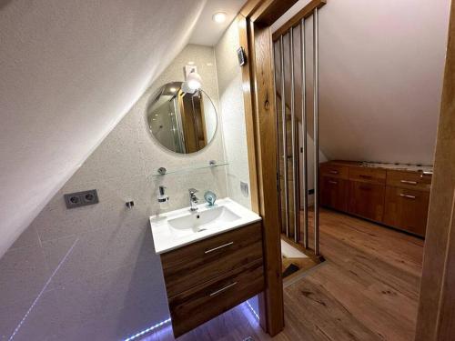 ein Bad mit einem Waschbecken und einem Spiegel in der Unterkunft Haus an der Sieber Zimmer 2 in Herzberg am Harz