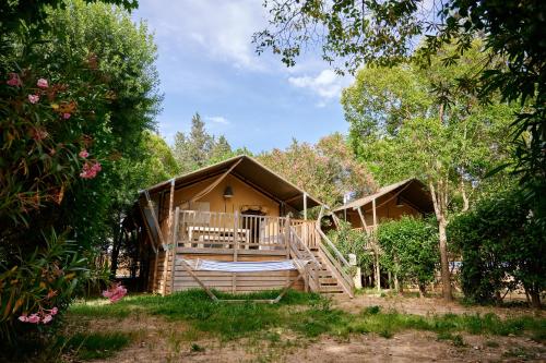 une cabane en rondins avec une véranda et une terrasse dans l'établissement Glamping Côte d'Azur, à Roquebrune-sur Argens