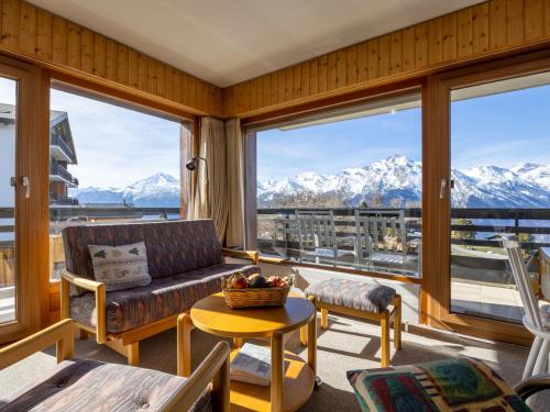 a living room with a couch and views of mountains at Apartment Muverans I L2 by Interhome in Nendaz