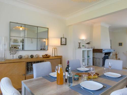 - une salle à manger avec une table et des assiettes ainsi que des bouteilles de vin dans l'établissement Holiday Home Cam Louis by Interhome, à Plouescat